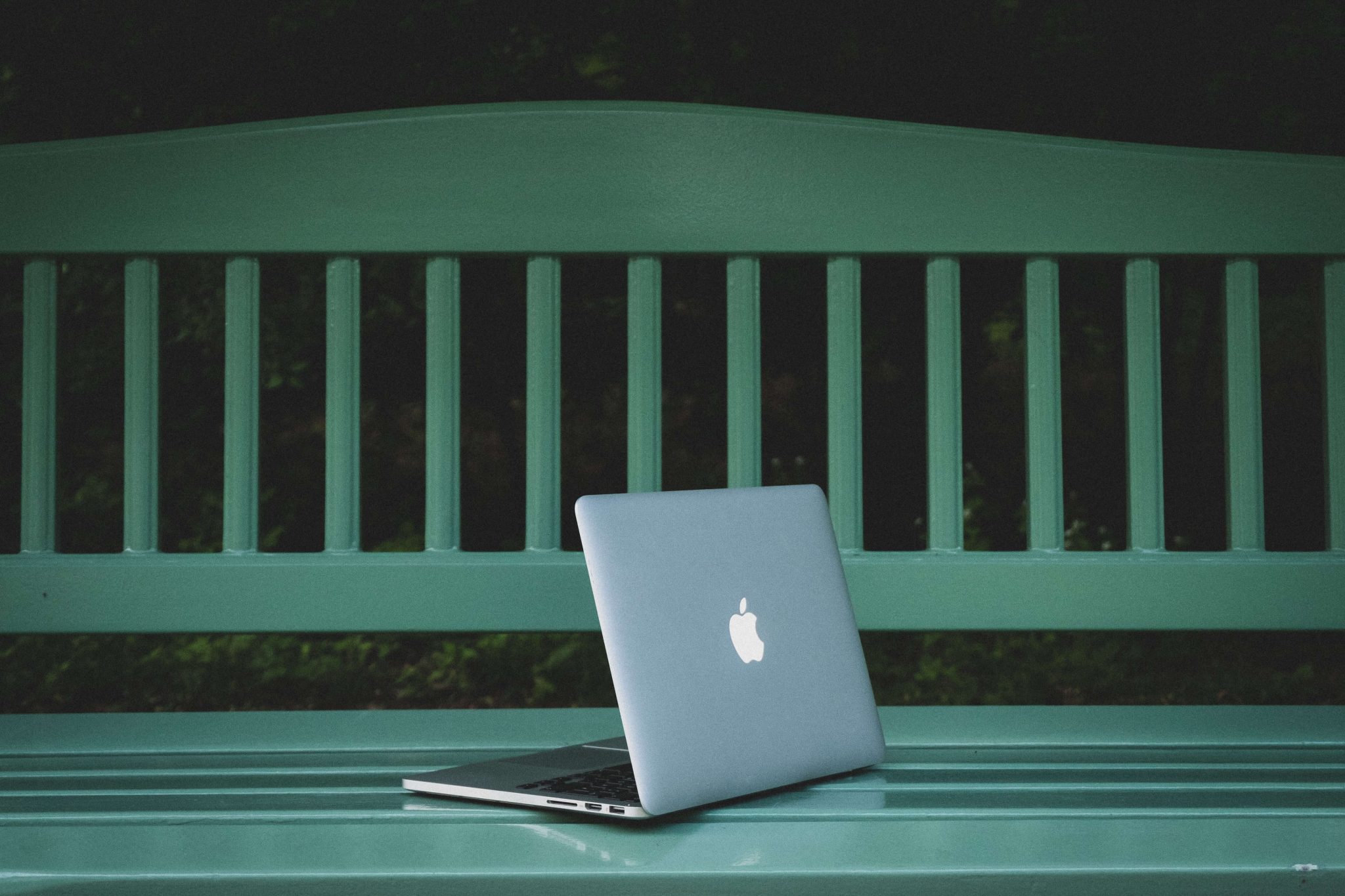laptop in a green bench